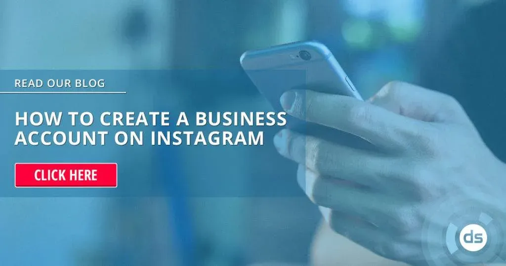 Person holding a smartphone with an advertisement in the background about creating a Business Account on Instagram.